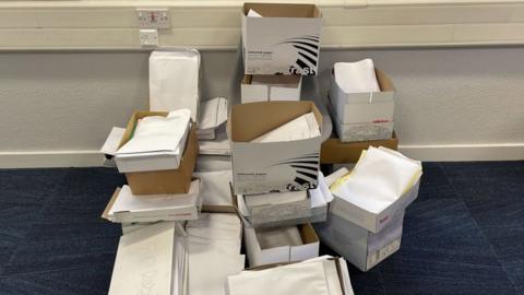 Piles of medical paperwork created by the cyber-attack