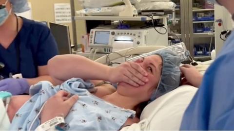 Kelsey Hatcher covers her mouth in happiness when her baby was delivered