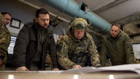 A handout photo made available by the presidential press service shows Ukrainian President Volodymyr Zelensky (L) taking part in a meeting with commanders at the headquarters of the Defense Forces near a frontline close to Kupiansk
