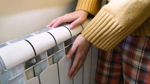 A person touching a radiator