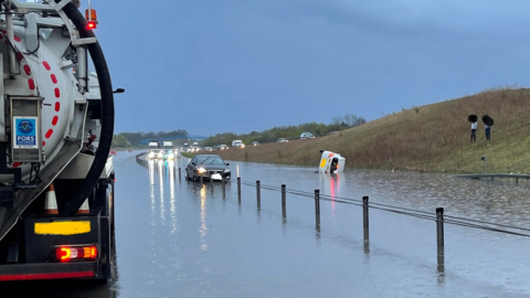An overturned car on a flooded A428