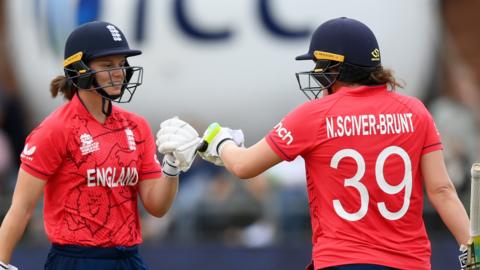 Amy Jones (left) and Nat Sciver-Brunt bump gloves during their partnership against India