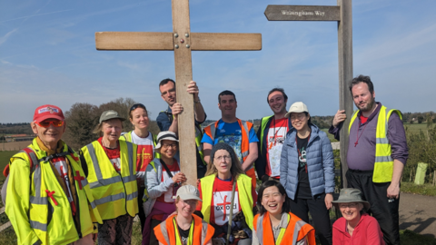 Christians on a pilgrimage carrying a wooden cross