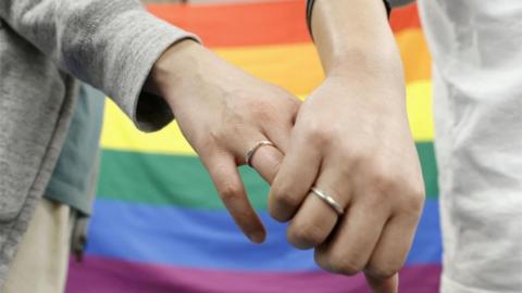 FILE PHOTO: Plaintiffs hold hands each other after a district court ruled on the legality of same-sex marriages outside Sapporo district court in Sapporo