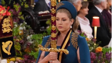 Ms Mordaunt carrying the Sword of State in the procession through Westminster Abbey