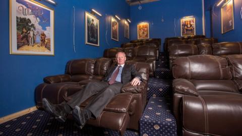 Graham Wildin sat in his cinema