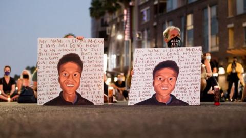 Protesters holding signs with Elijah McClain's face