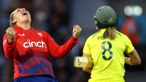 England bowler Sophie Ecclestone (L) celebrates the wicket of Ellyse Perry (R)
