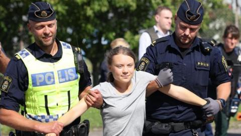 Swedish climate activist Greta Thunberg is carried away by police officers during a climate action in Oljehamnen, Malmo, Sweden, 24 July 2023