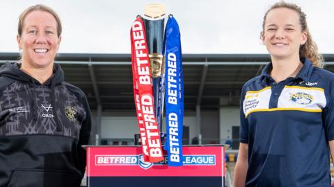 Lindsay Anfield and Lois Forsell stand either side of the Women's Super League trophy for a promotion shot