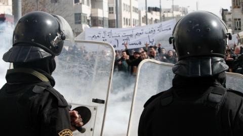 Palestinian policemen stand opposite demonstrators during a protest against a decision by the Palestinian Authority to grant public land to the Russian church, in the West Bank city of Hebron, on 4 February 2017