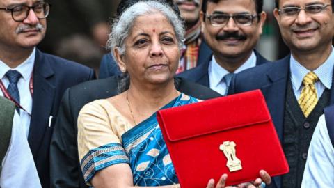 Nirmala Sitharaman, India's finance minister, center, leaves to present the budget at the parliament on Thursday