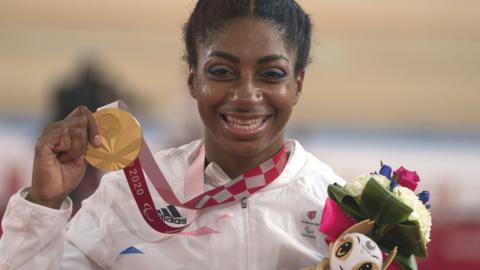 Kadeena Cox holds her gold medal aloft after winning the women's C4-5 500m time trial at the Tokyo Paralympics