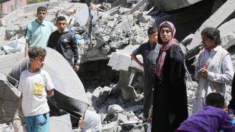 Palestinians living in al-Maghazi Refugee Camp collect the usable items among the rubble of the destroyed buildings following an Israeli attack in Deir al-Balah, Gaza on 4 April 2024