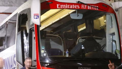 One window (left) completely broken and another damaged after an attack on Lyon's team bus