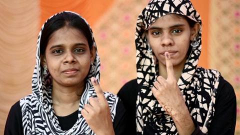 Women show their inked finger after casting their ballot to vote at a polling station as voting starts in the first phase of India's general election in Chennai, capital of India's Tamil Nadu state on April 19, 2024. (