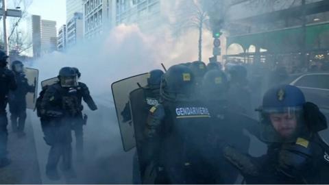 Paris police with riot shields in clouds of tear gas