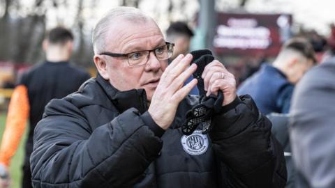 Steve Evans applauds the Stevenage fans