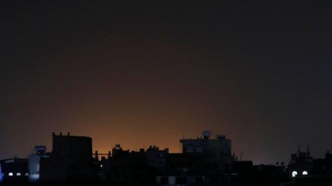 Light shining behind buildings at a neighbourhood following strikes in Sana'a, Yemen on Saturday