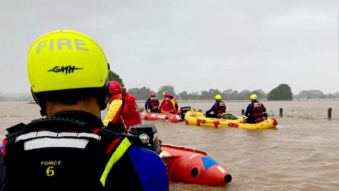 A fire and rescue response team on rescue kayaks during the NSW floods