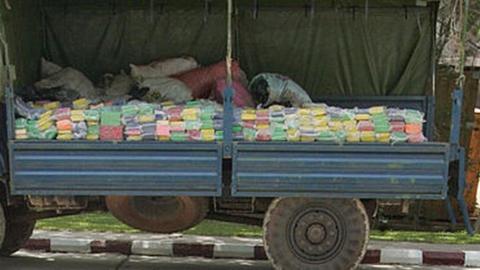 Gendarmes sit in front of a truck with a large part of the seized cocaine haul at a cement furnace in Rufisque near Dakar 02 August 2007 during the incineration of 2.475 tonnes of cocaine, seized in Senegal between the end of June and the beginning of July