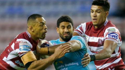 Wigan's Willie Isa and Kai Pearce-Paul look to wrap up Leeds' Nene MacDonald