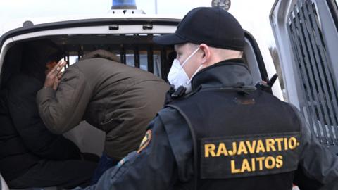 Finnish border guards transport asylum seekers who arrived from Russia on 16 November