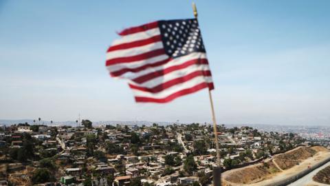 A flag flies over the US-Mexico border
