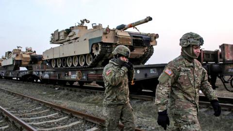 US soldiers walk next to M1 Abrams tanks at the Mihail Kogalniceanu Air Base, Romania, February 14, 2017