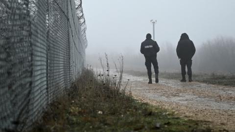 Bulgarian border police officers patrol the border fence