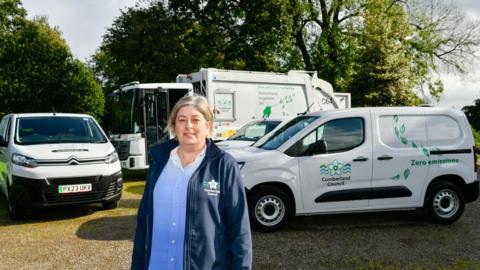Councillor Denise Rollo standing in front of Cumberland Council refuse collection vehicles