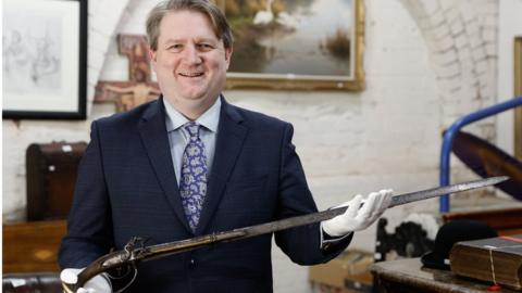 Boomfield Auctions Managing Director Karl Bennett with a sword pistol linked to the 1689 Siege of Derry