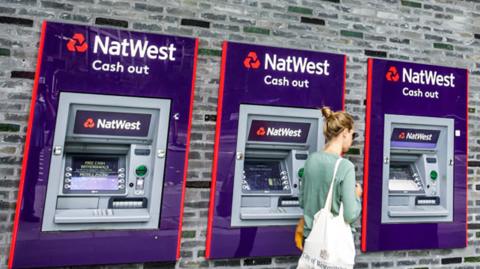 Woman at NatWest cash machines