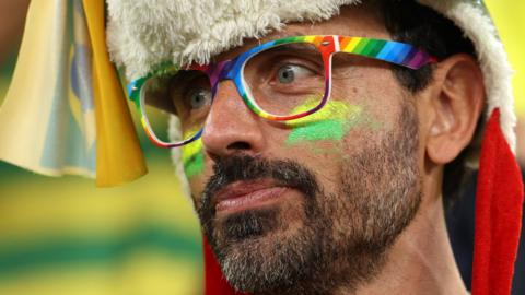 A Swiss supporter wears rainbow glasses in support of LGBTQ+ rights