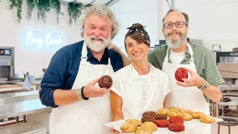 Anna Tyler holding a tray of cookies pictured with the Hairy Bikers