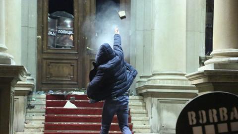 Protestors throw rocks staging a protest in front of Belgrade City Council building