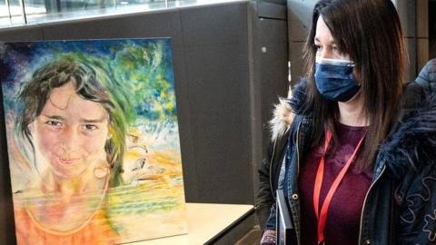 Jennifer Cleyet-Marrel walks by a painting of her daughter Maëlys as she arrives at the Grenoble courthouse where the trial of Nordahl Lelandais who is accused of her murder is taking place on 1 February 2022