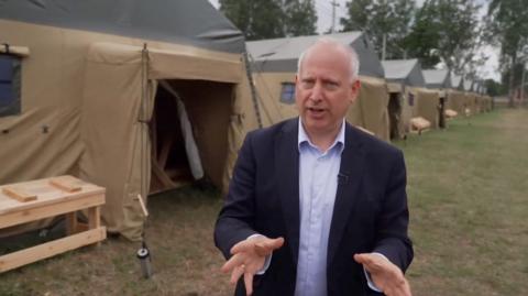 Steve Rosenberg in front of tents