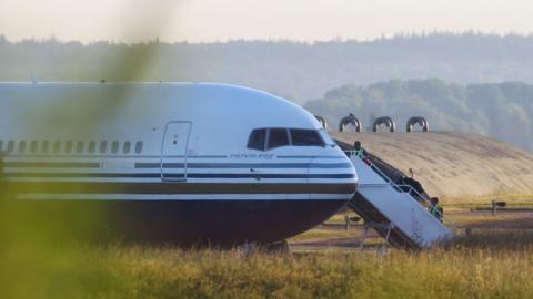 Members of the staff board a plane reported by British media to be first to transport migrants to Rwanda, at MOD Boscombe Down base in Wiltshire, Britain, June 14, 2022.