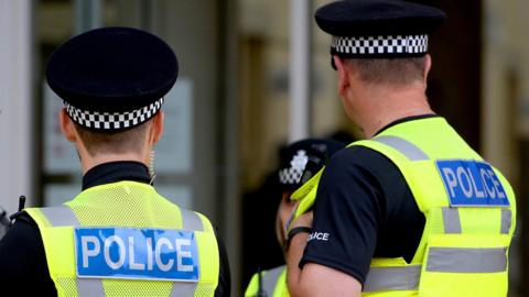 A pair of police officers facing away from the camera