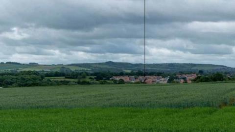 A large field with arrows pointing to where the development would have been built