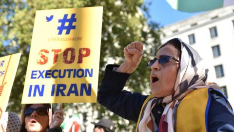 People protest against the death penalty in Iran opposite Downing Street as a march to demand a people's vote against Brexit passes by on October 20, 2018 in London, UK