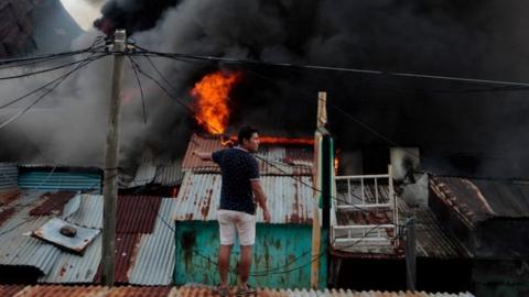 A man looks at a fire at the oriental market, considered one of Central America"s largest markets, in Managua