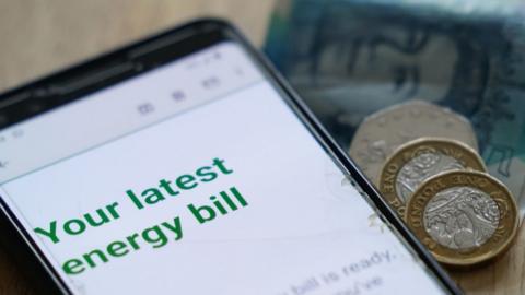 Generic energy bill on a mobile phone screen and some cash