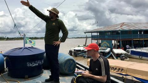 Dom Phillips, sitting, and Bruno Pereira on the Amazon in 2018