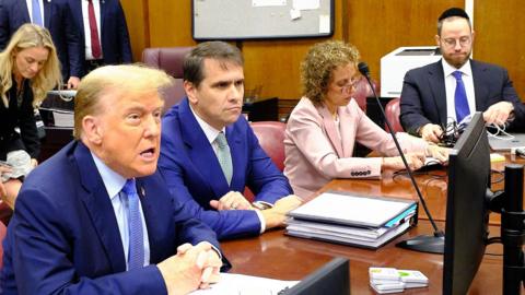 Donald Trump sits in a court room