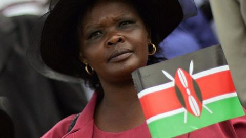 A woman carrying a Kenyan flag