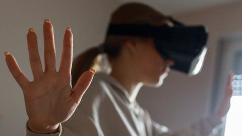 Stock image of a girl, blurred, using a VR headset.