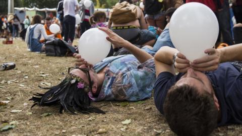 Revellers inhale nitrous oxide from balloons