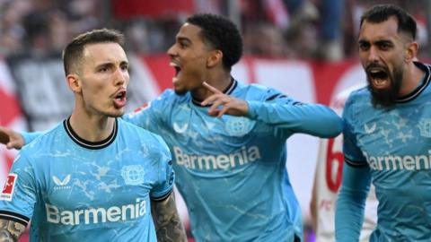 Bayer Leverkusen players celebrate scoring at Cologne